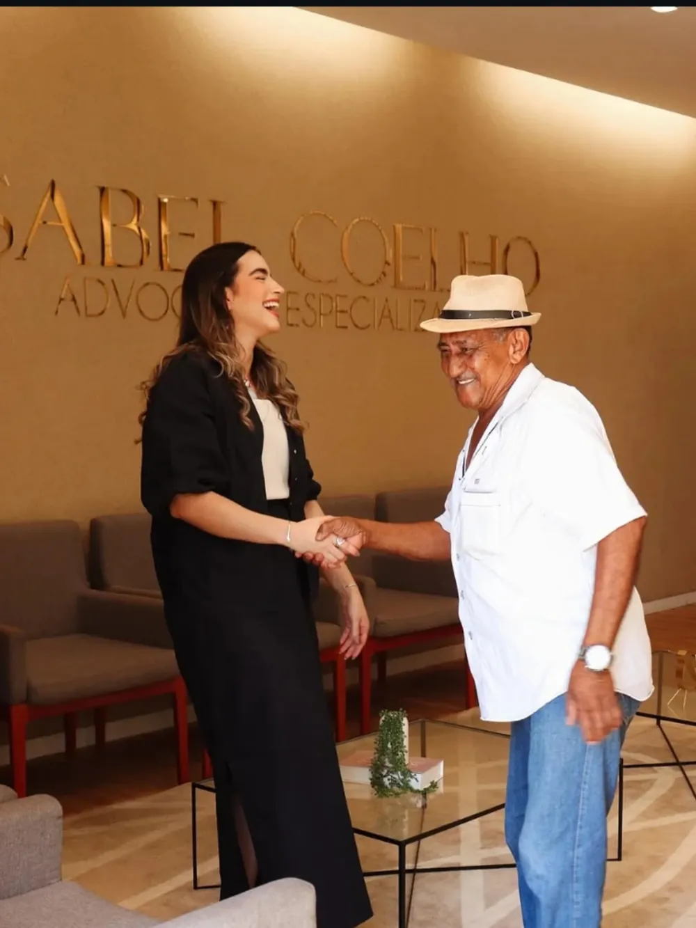 Elaine Castro apertando a mão de um cliente idoso durante atendimento